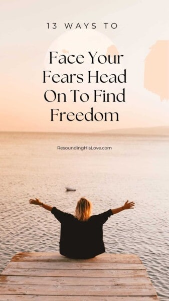 a woman sitting on the end of a dock overlooking a lake with her hands raised in praise with text 13 Ways to Face Your Fears Head On to Find Freedom