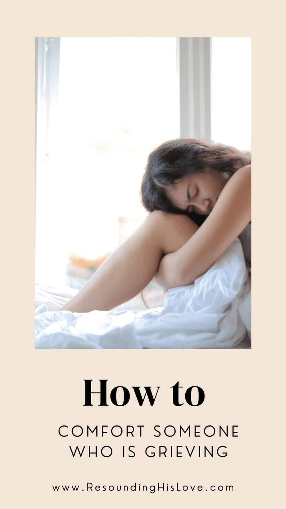 a woman sitting in a bed clutching a white pillow in grief with text How to Comfort Someone Who is Grieving