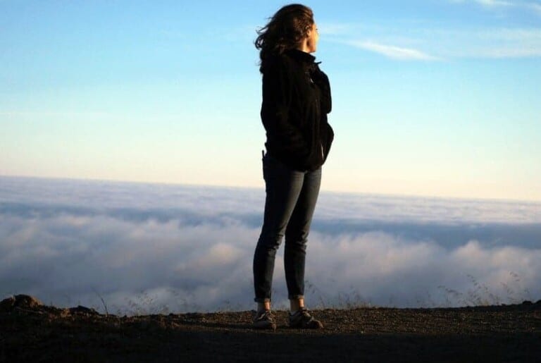 an image of woman overlooking a sunset over the horizon overcoming the spirit of fear concept