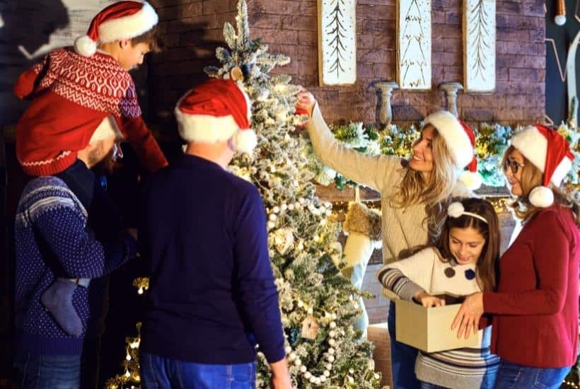 a family decorating a Christmas tree featured image for Remembering Loved Ones At Christmas