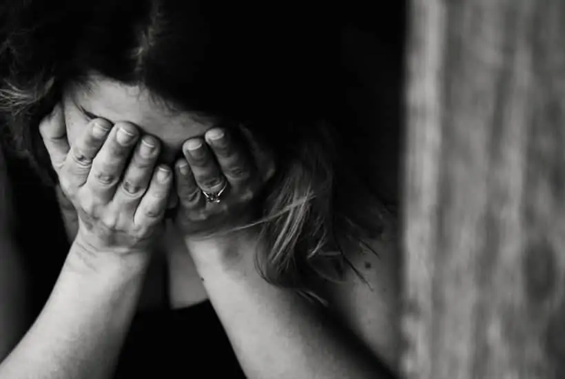 an image of a woman clasping her hands to her face crying featured image for Shattered: Mad at God