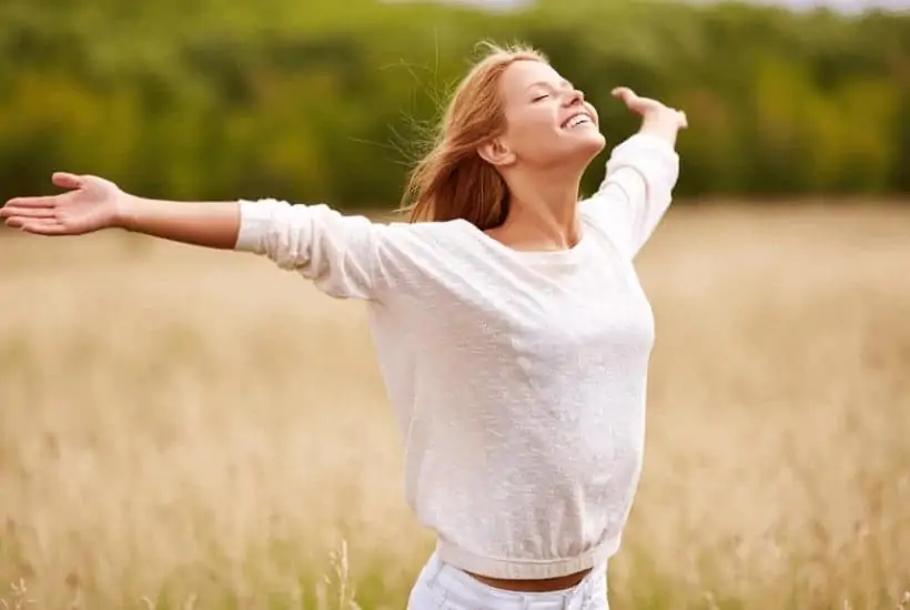 an image of a woman with her hands spread wide in an open field with text reading Worship God: A Pure Heart of Worship